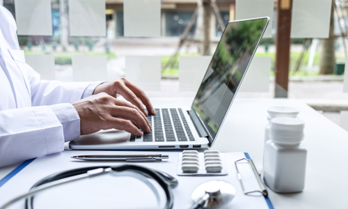 Image of a physician working on his computer.